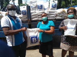 L-R: Executive Chairman, Agege LG, Hon. Kola Egunjobi, receiving bags of assorted palliatives from Mrs Funke Obolo of Lagos Facility Works, Region West, Julius Berger. Extreme left is Mrs Lisa San-Ngbor of same department Tuesday.
