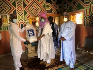 L-R; Ibrahim Yusuf of Julius Berger AKR Project presents food palliatives to the District head at Kura in Kano State, recently
