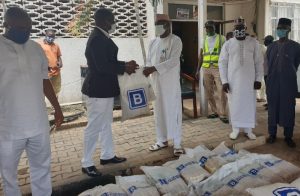 The Group Head, Media Relations Office of Julius Berger Plc, Prince Moses Duku, presents the JBN food palliatives to the AMAC Chairman, Hon. Abdullahi Adamu Candido in Abuja last Tuesday