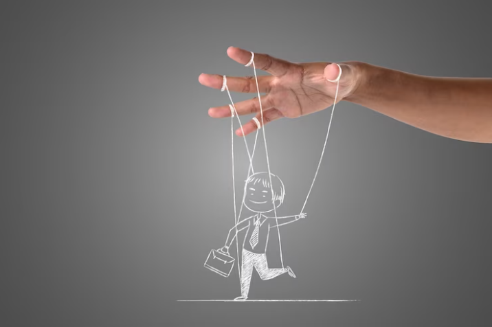 A hand controlling a puppet with strings